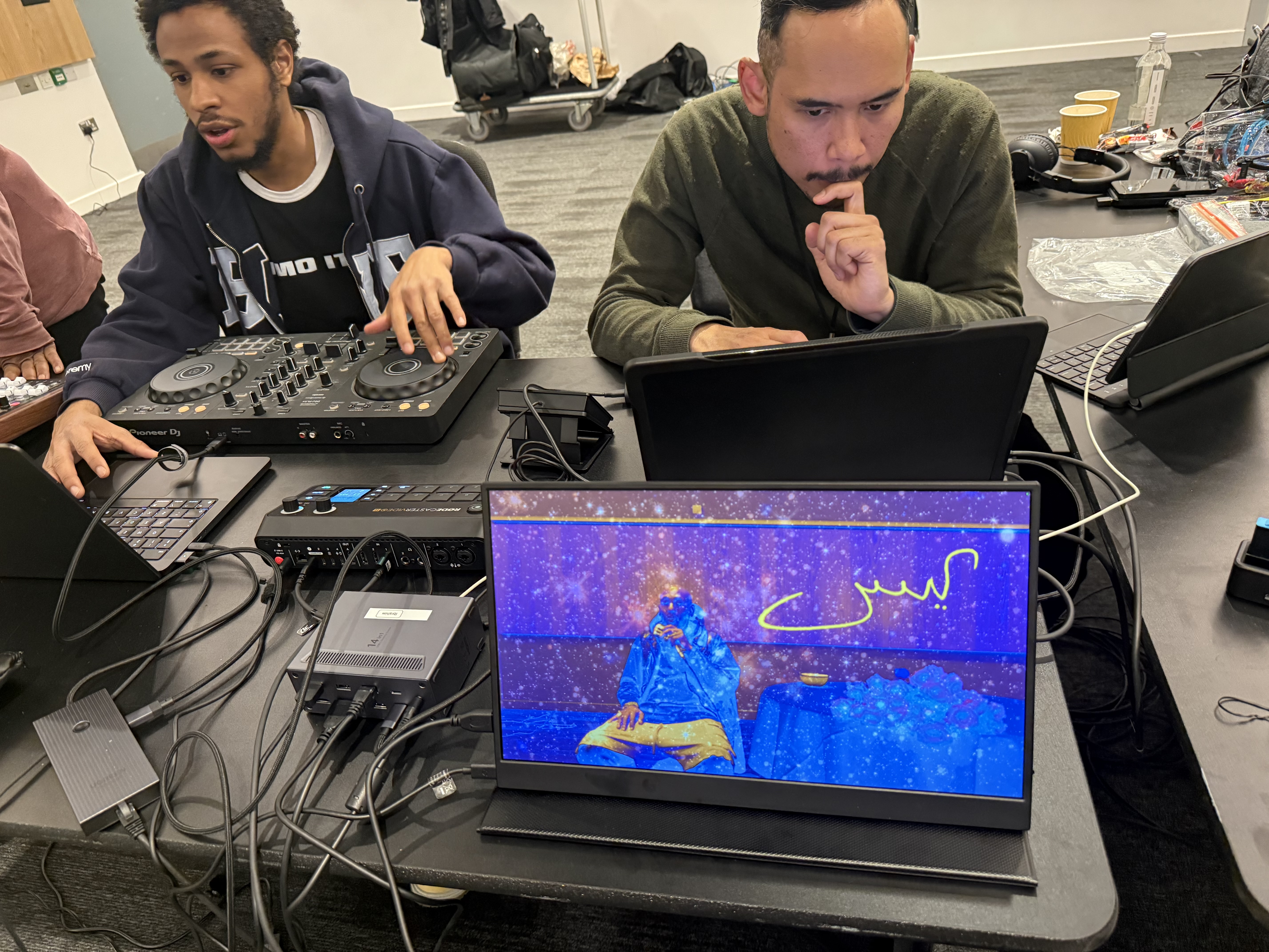 Production table with DJ controller, laptop and The Local Time visual monitor