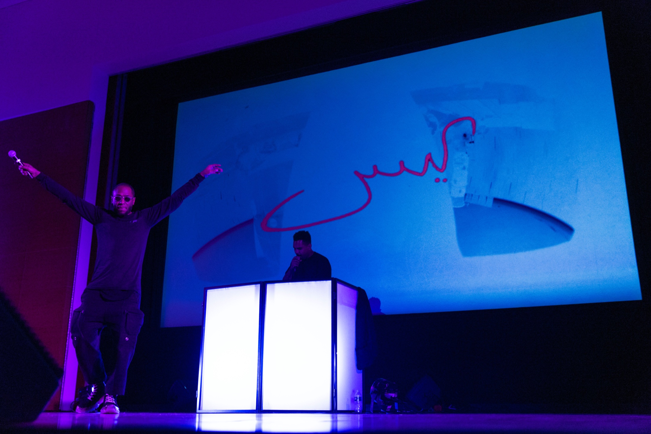 Yasiin Bey holding a microphone beside Lord Tusk during the Negus performance