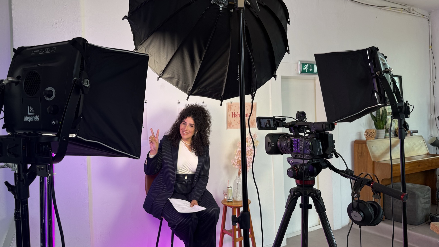 Host seated between production lights